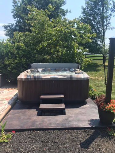 A hot tub on a paved patio.