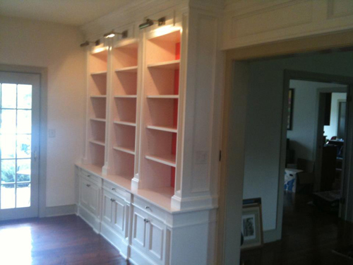 Adjustable fixtures illuminate a wall of built-in shelving.