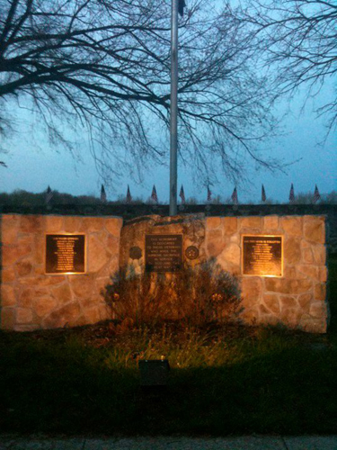 Warm exterior lighting brings out the texture of a stone wall.