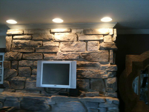 Ceiling lights highlight a stone feature wall.