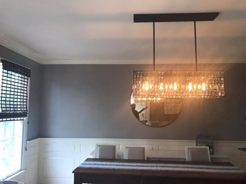 A rectangular chandelier above the dining table.
