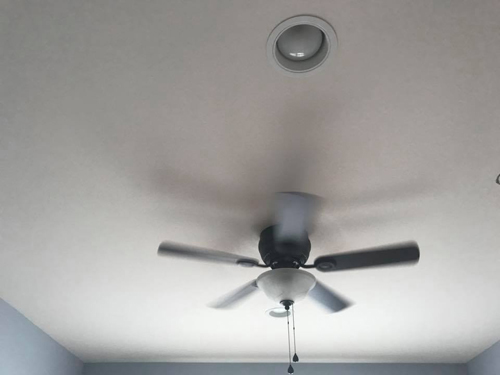 A ceiling fan paired with a recessed ceiling fixture.