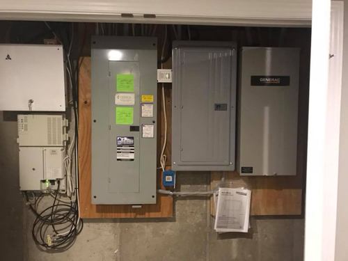 A main panel and generator transfer enclosure in a utility area.