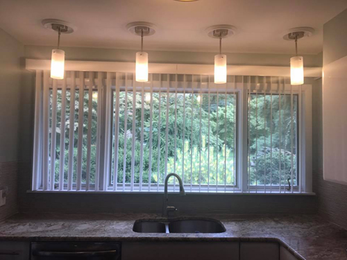 Four pendant fixtures across a kitchen window.